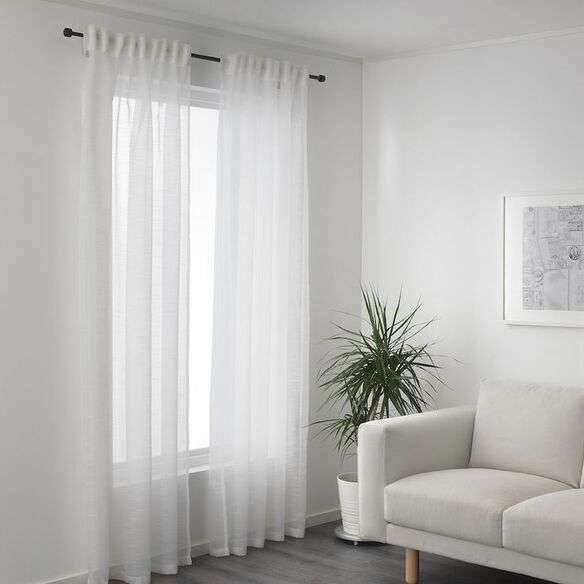 Sheer white curtains in a small living room with natural light.