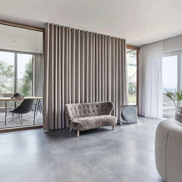 Floor-to-ceiling beige curtains making a small living room appear taller.