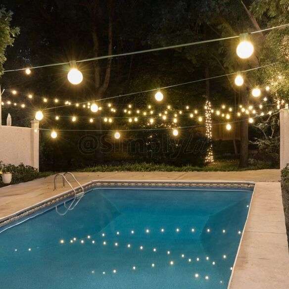 Floating LED lights glowing in a backyard swimming pool during an evening party