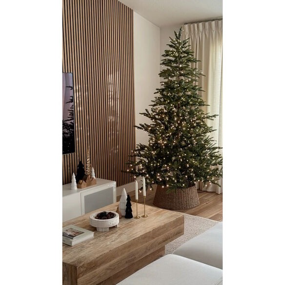 Modern minimalist Christmas tree with white and natural wood ornaments in Scandinavian-style living room