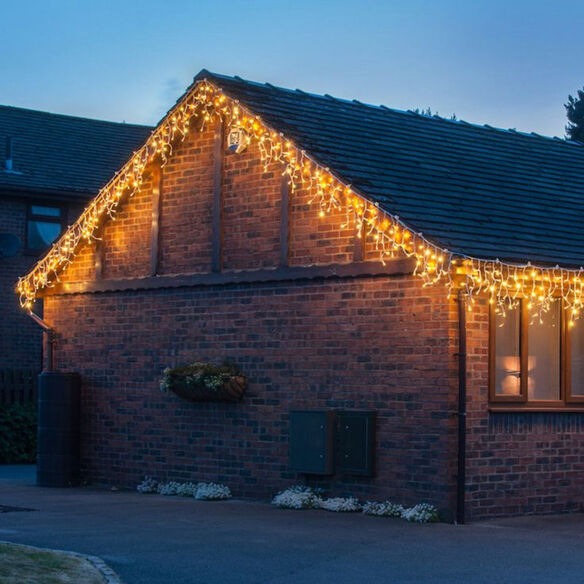 Professional roofline Christmas light installation with icicle lights and even clip spacing